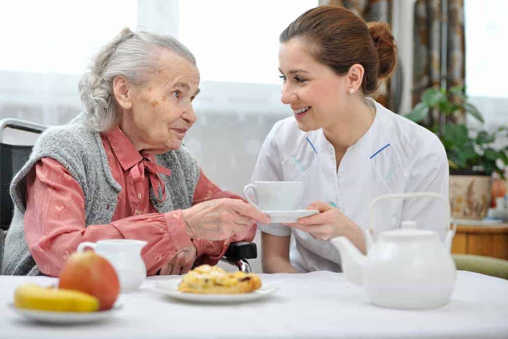 Senior woman with a home caregiver smiling and happy - personal home care services