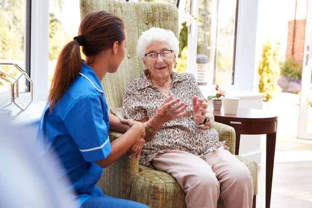 Elderly woman having a good time outdoors with a female caregiver - average cost of memory care