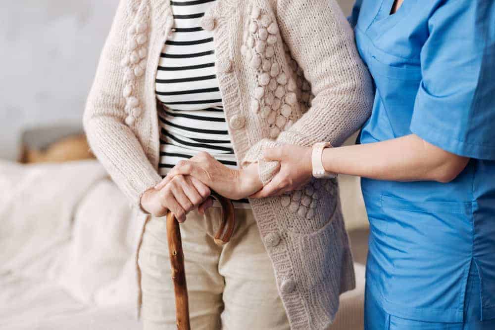 a live-in caregiver assists an aging woman - 24-hour home care