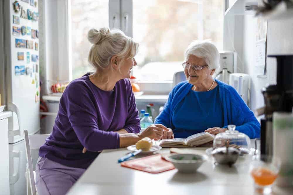 a daughter discussing the different types of care homes near them with her aging mother