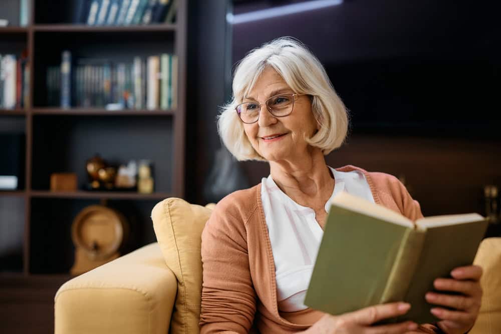 senior woman enjoying a book in an independent living facility