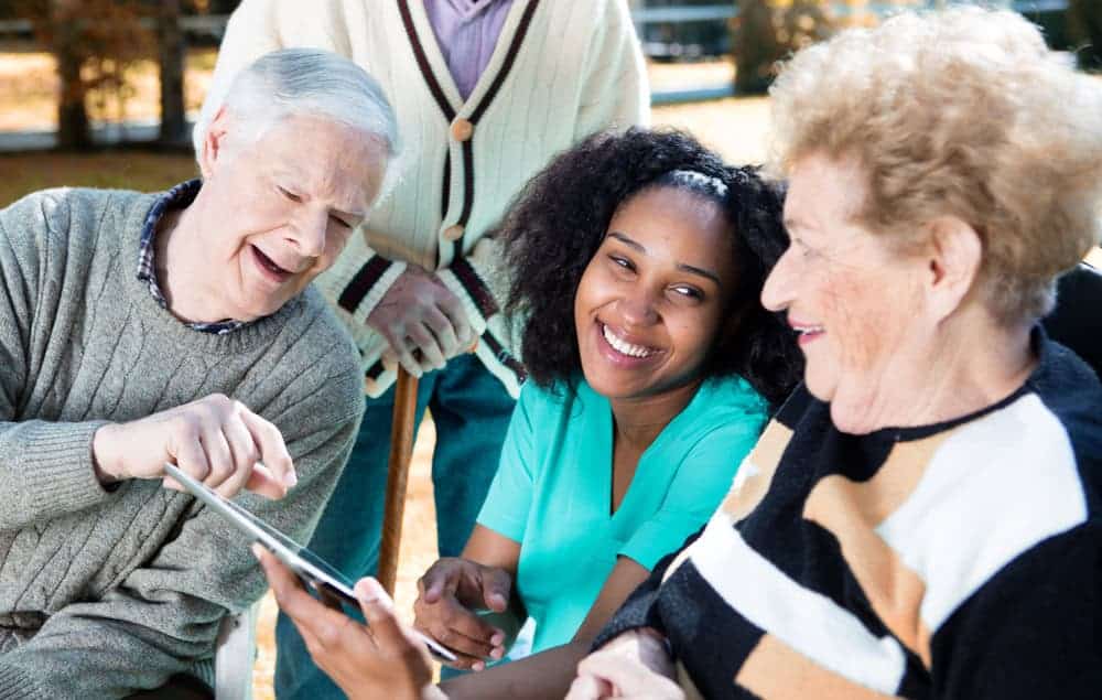 home health aide assistant proving companionship to a group of older adults