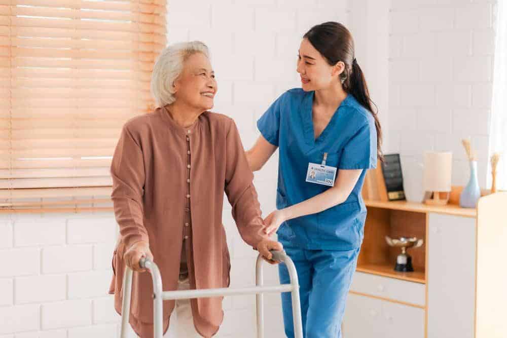 Health aide helping an elderly woman with physical therapy exercises