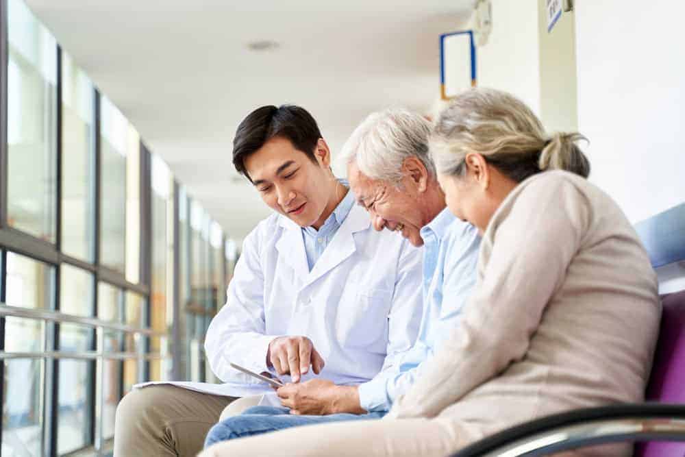 medical professional discussing with senior and his family - home health care medicaid