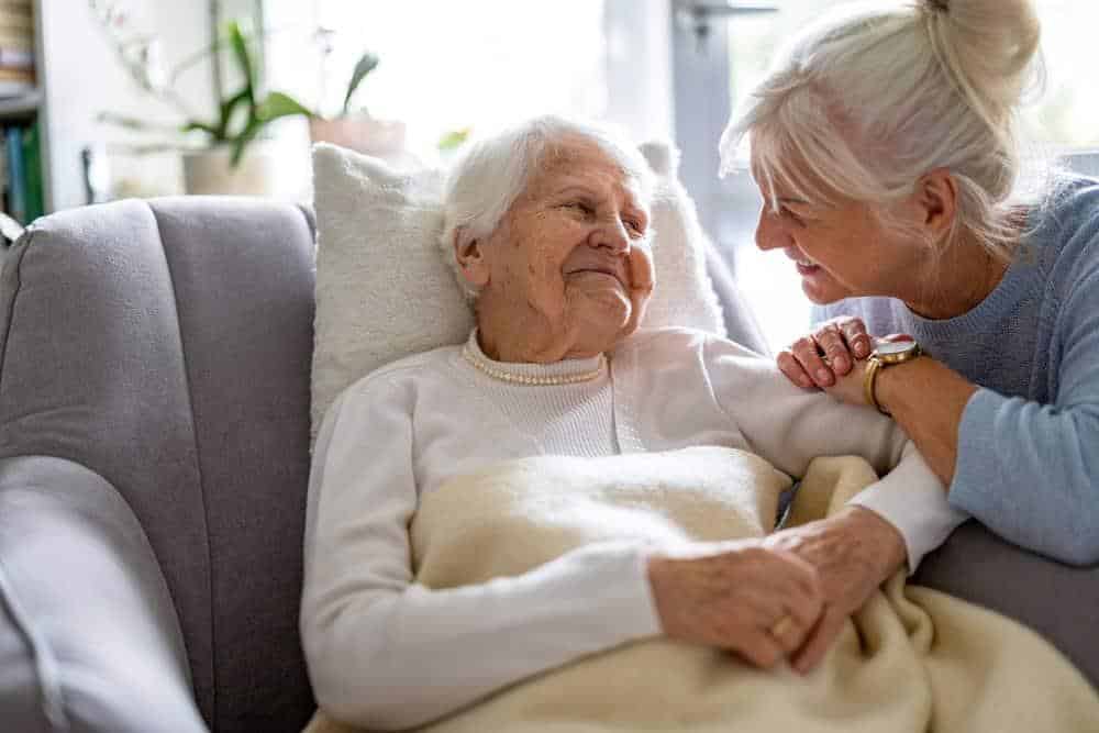 Senior woman receiving help at home services with her daughter