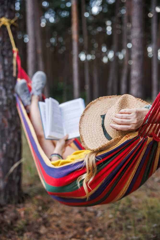 a family caregiver relaxing with a book after hiring a respite caregiver for the day