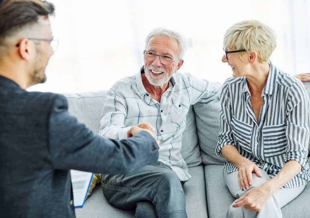 A senior couple talking to a financial advisor | cost of elderly home care