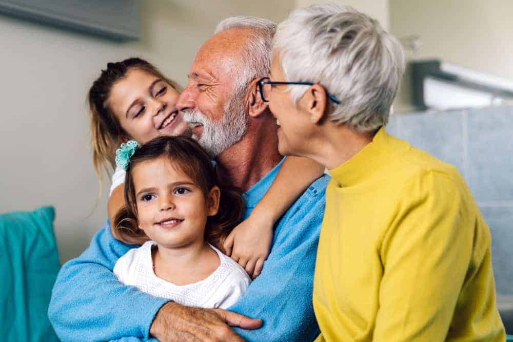 a happy grandfather enjoying his grandchildren's visit to him in his care home