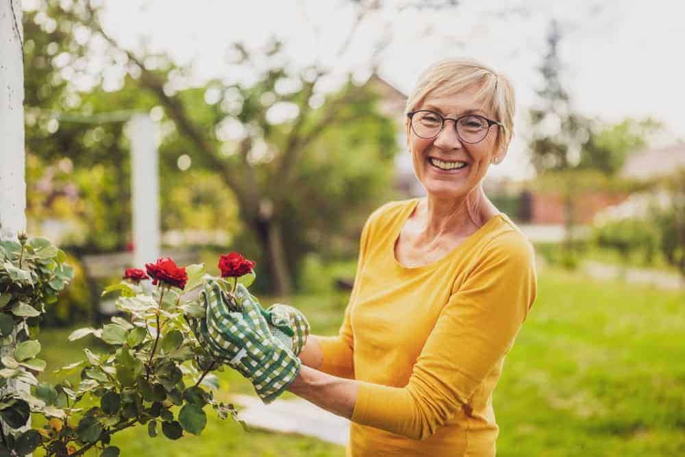 a happy woman gardening at a residential care home