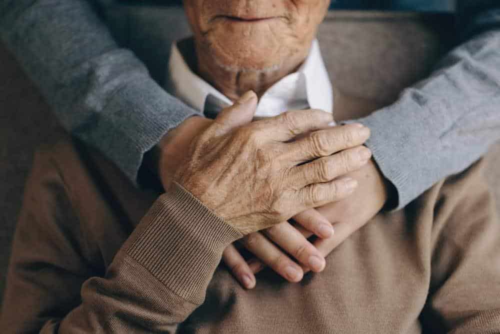 a son hugging his father during a level of care assessment in a residential care home for seniors