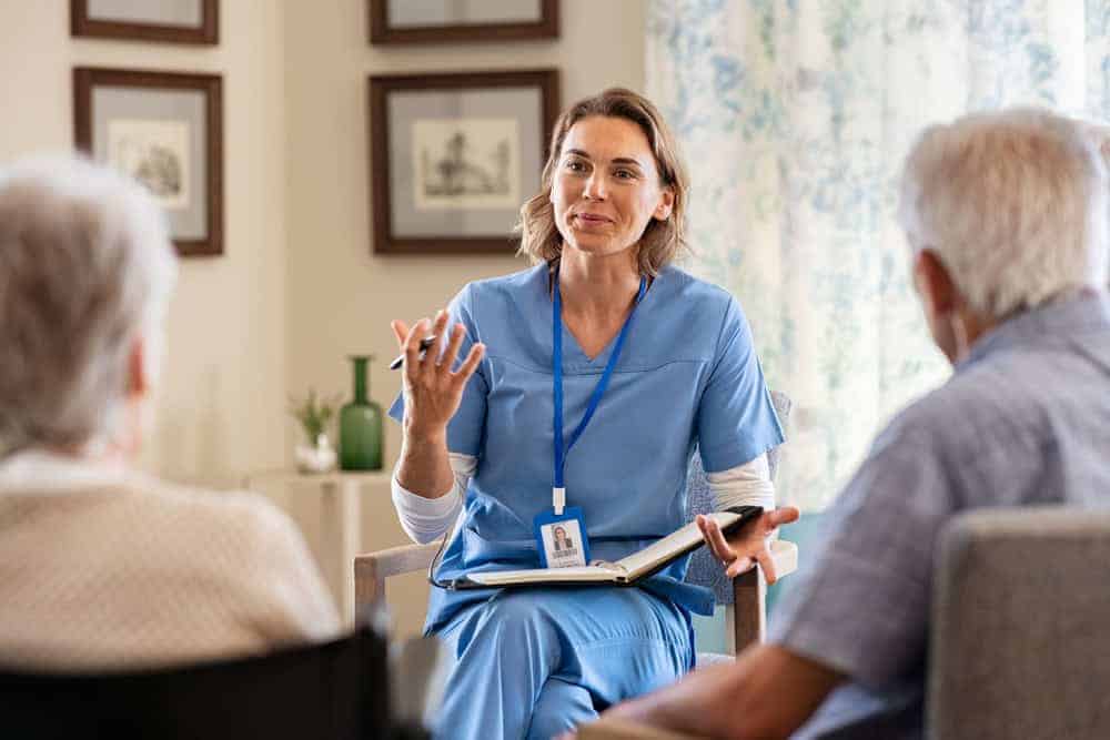 A female nurse explaining something to a senior couple | health care services