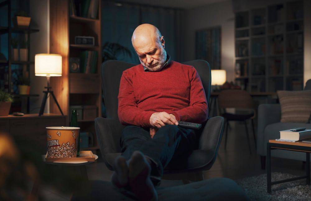 an older man napping in an armchair - overnight elderly care