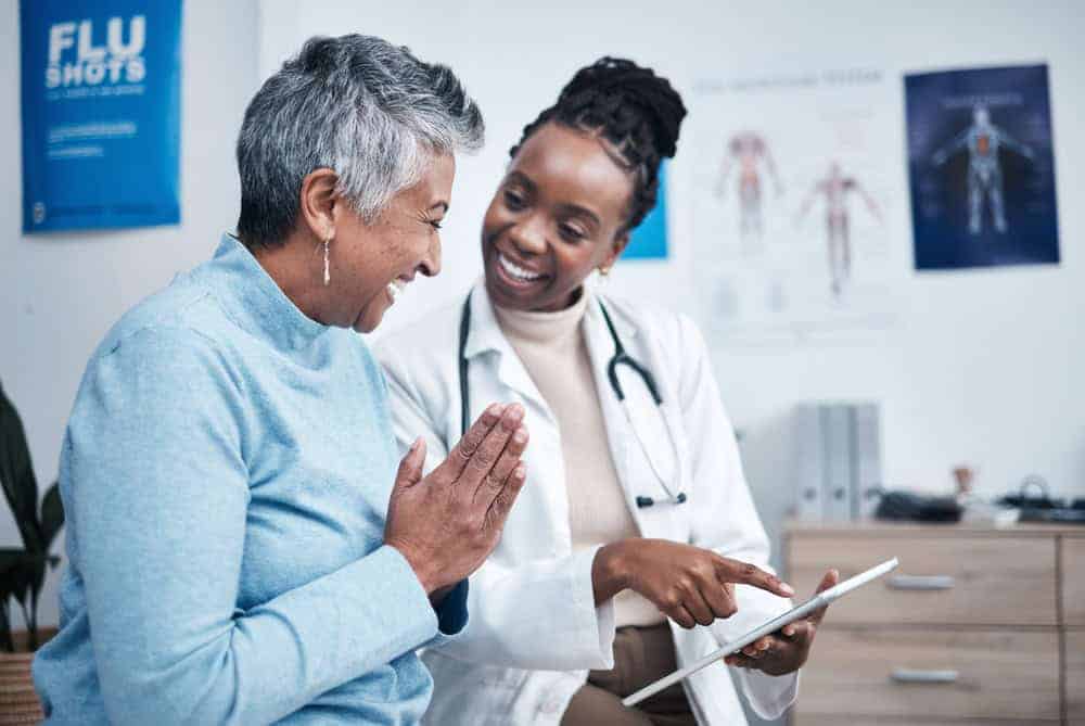 a senior woman comparing notes with her caregiver about the available private home health care providers