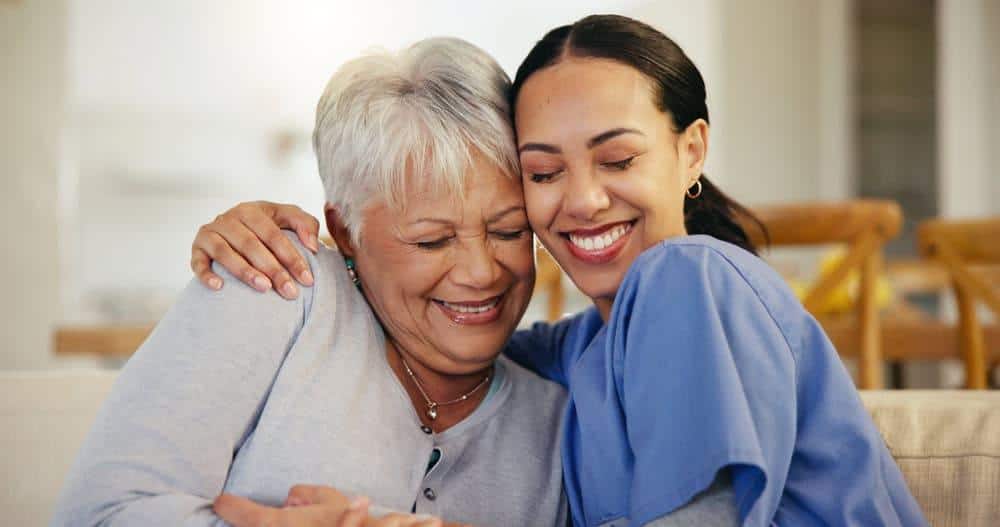 caregiver hugging older adult woman - cost of at home care