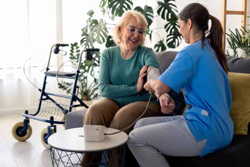 A nurse visiting a senior to take her vitals | at home medical care.