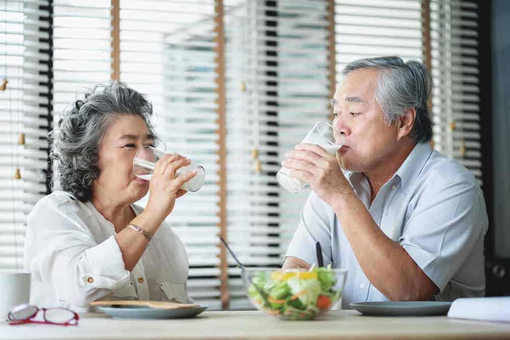 an older couple enjoying Ensure milk drink