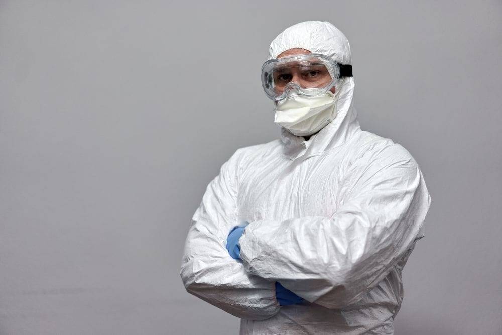 a doctor adjusting goggles, part of the personal protective equipment