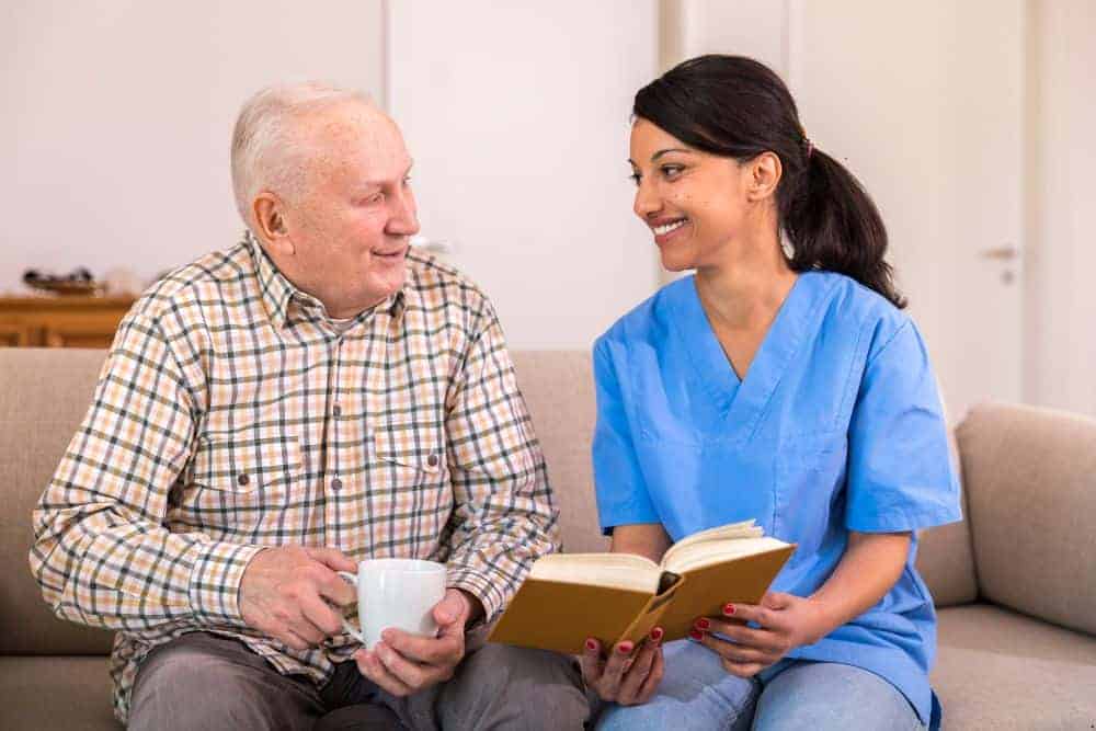 a caregiver explaining to a senior resident how to prevent the spread of infections