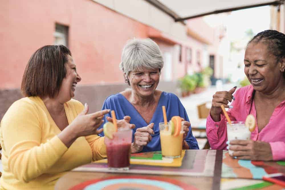 senior women talking and drinking different smoothies