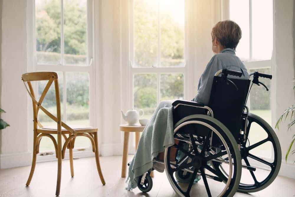 senior woman sitting in a wheelchair feeling alone