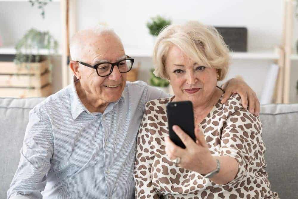 Senior couple keeping in touch with family over video chat