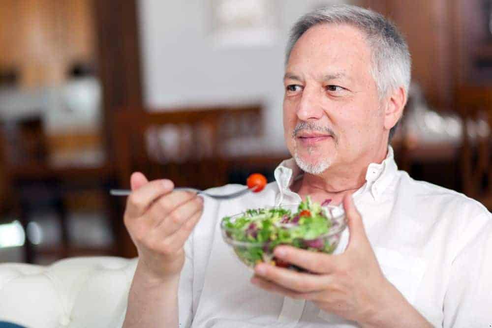 an elderly man enjoying a healthy salad