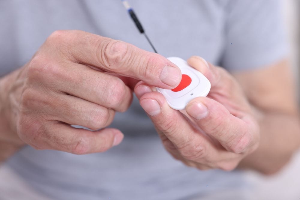 Elderly man pressing the emergency button on a medical alert system