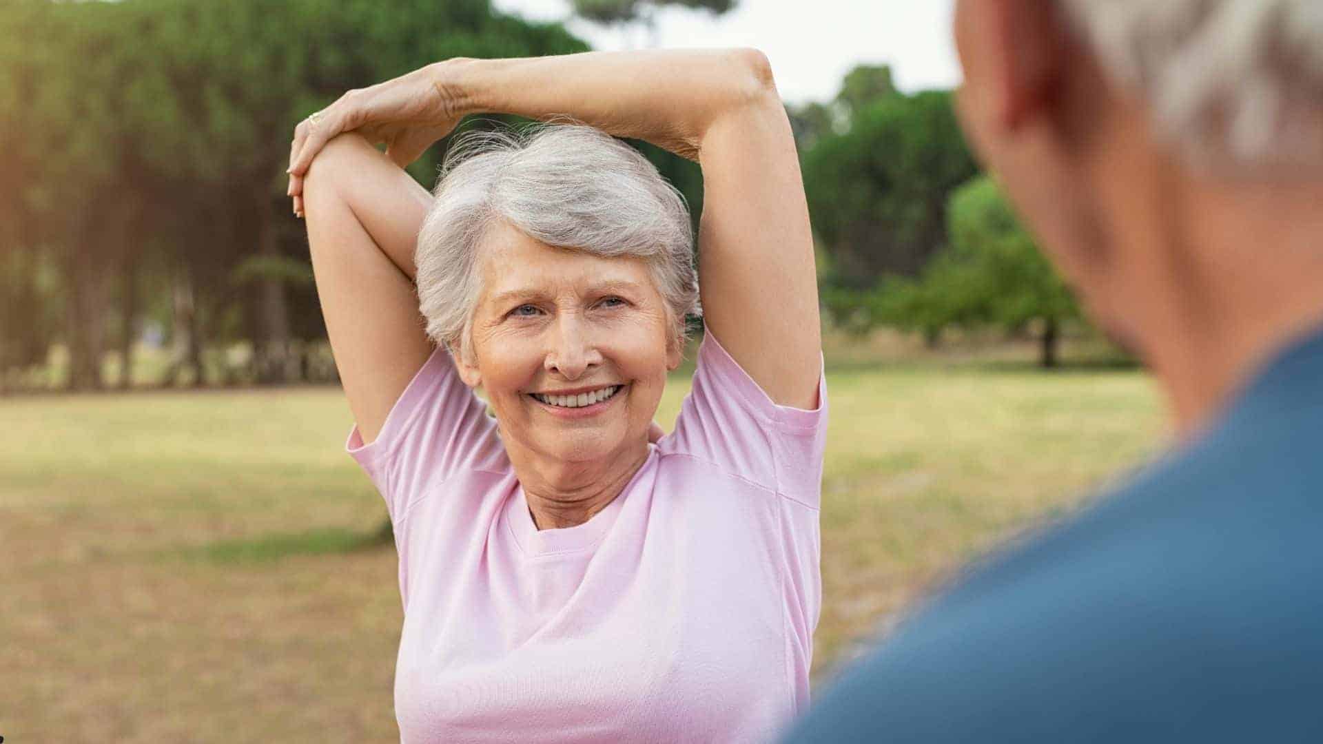 senior woman smiling while stretching her arm