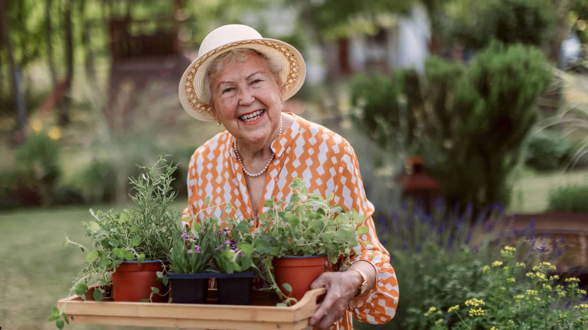 an older woman with potted plants happy to be independent