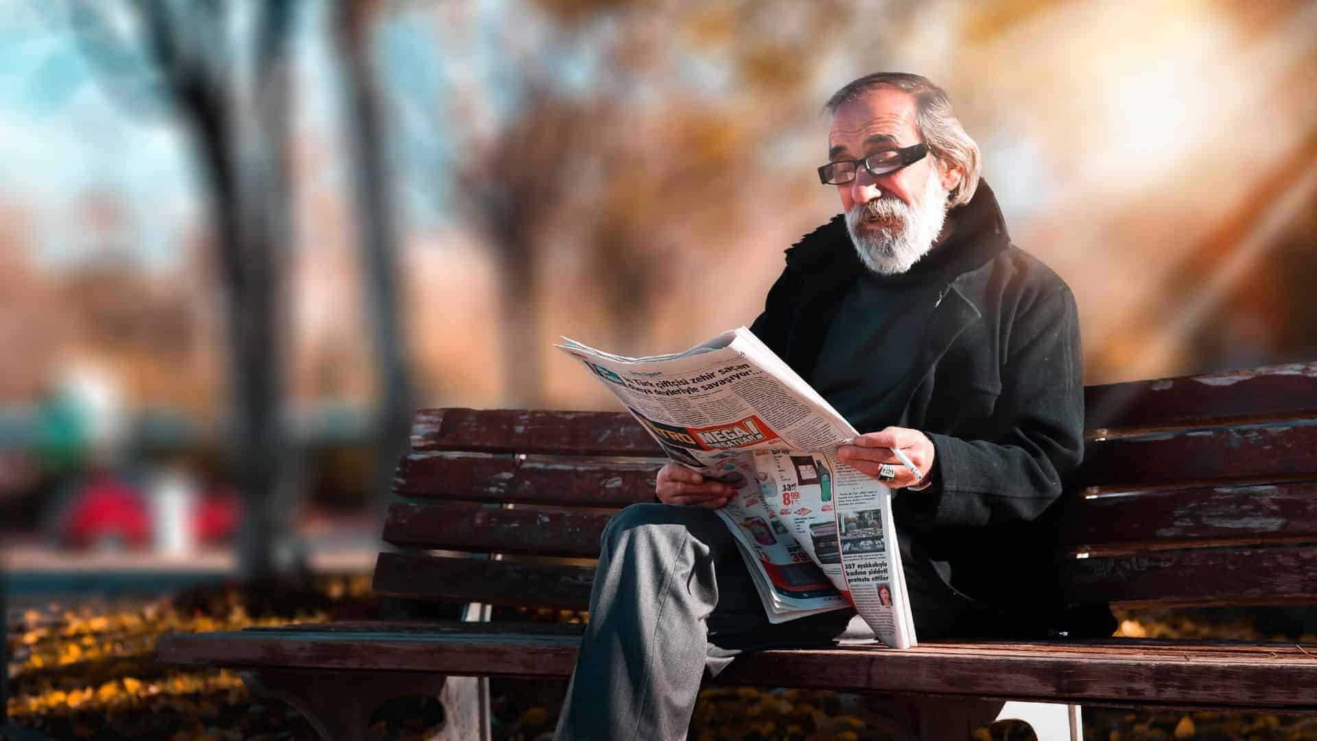 a senior man reading a newspaper