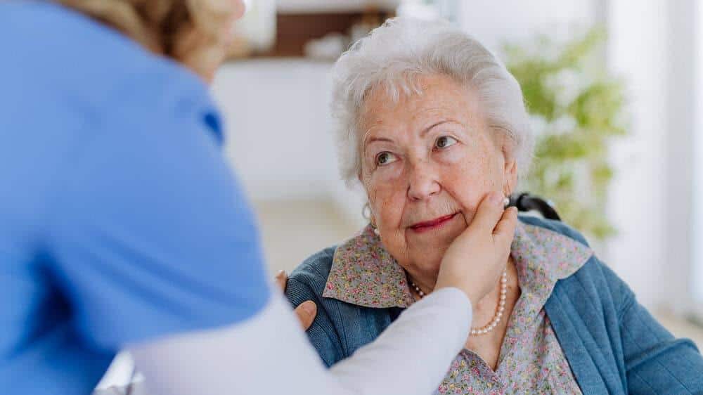A caregiver providing personalized care and cognitive stimulation to a resident in a Reno memory care unit.