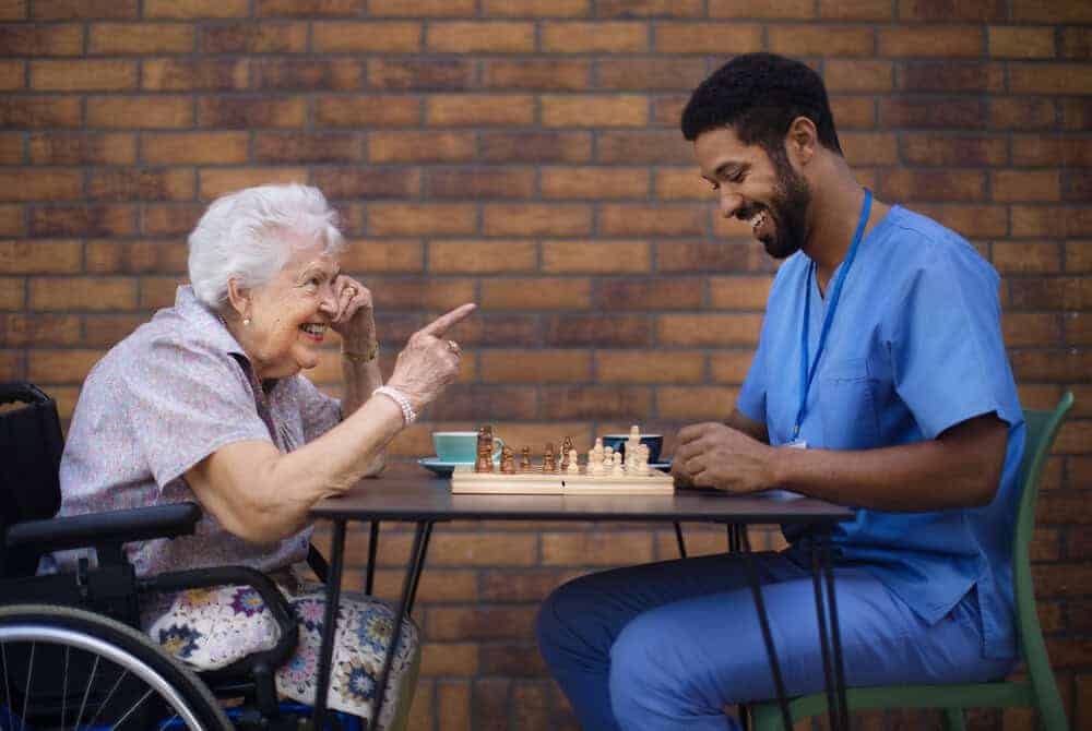 A caregiver and resident enjoying an activity together thanks to a high staff-to-resident ratio.
