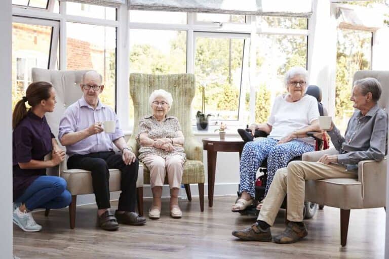 Seniors socializing in a bright, comfortable common room of an assisted living home