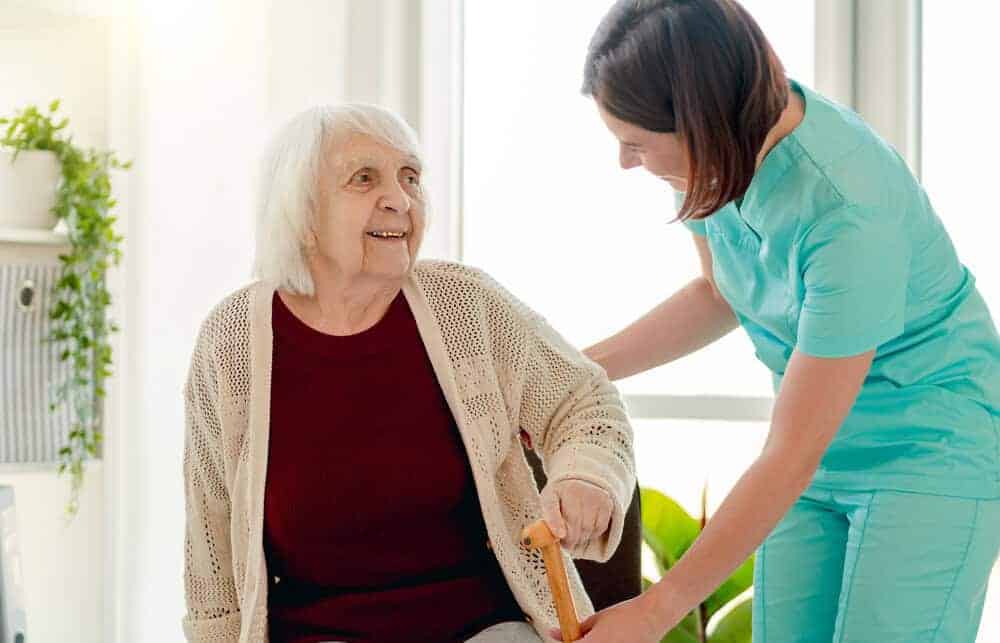 A compassionate caregiver assisting an elderly resident with kindness