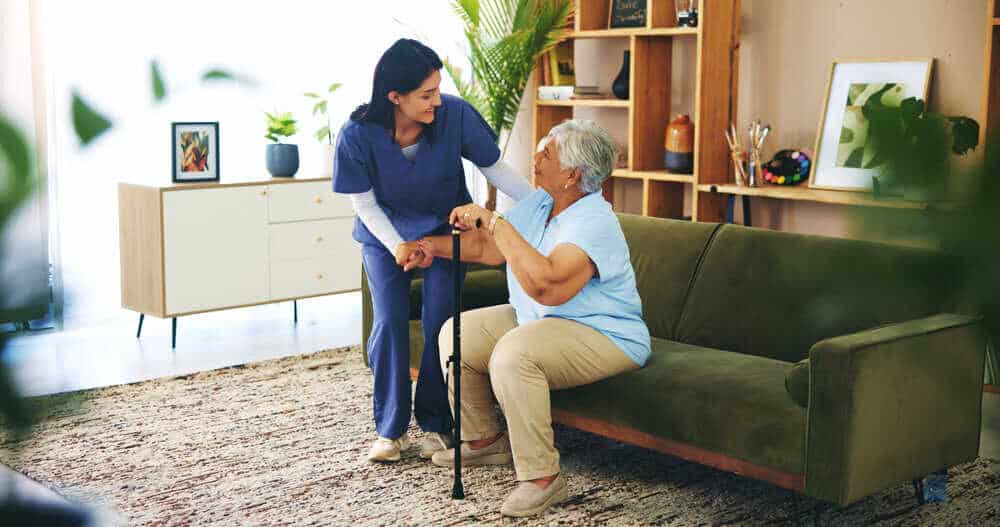 A caregiver providing personal care assistance to a senior resident in a home.