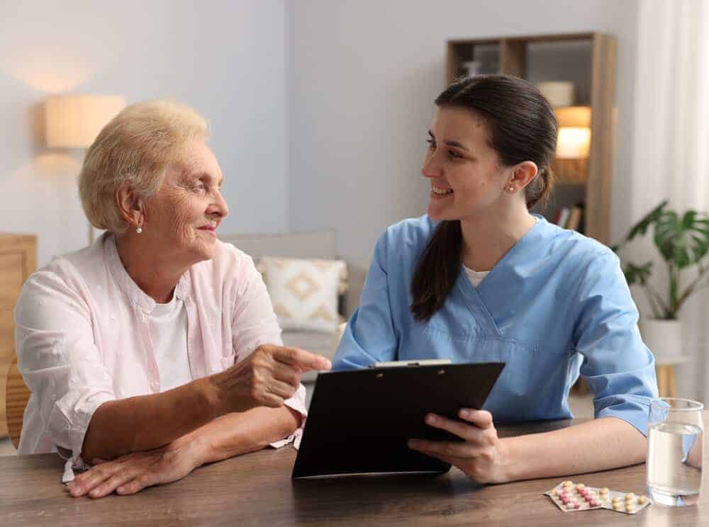 Caregiver and resident discussing all-inclusive assisted living costs in a Carson City home.
