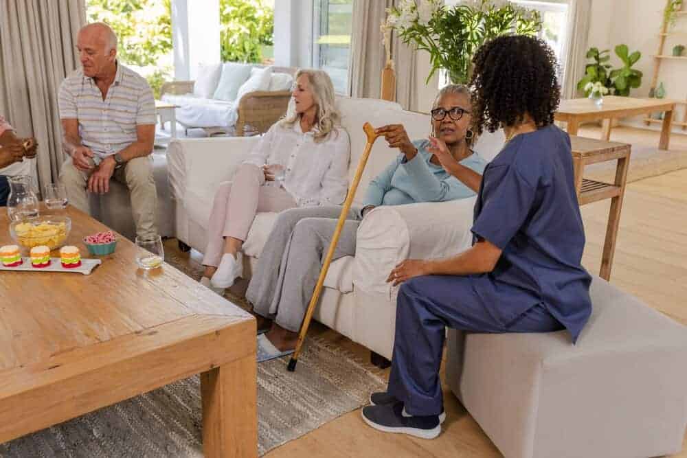 Seniors and a caregiver enjoying an activity in a cozy residential care home.