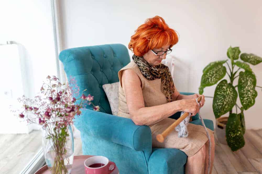 A senior woman maintaining her independence and hobbies in a residential care home.