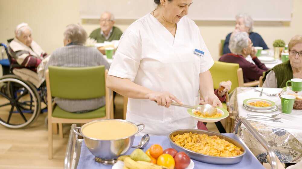 A large, traditional senior living community dining hall with a lower staff to resident ratio.
