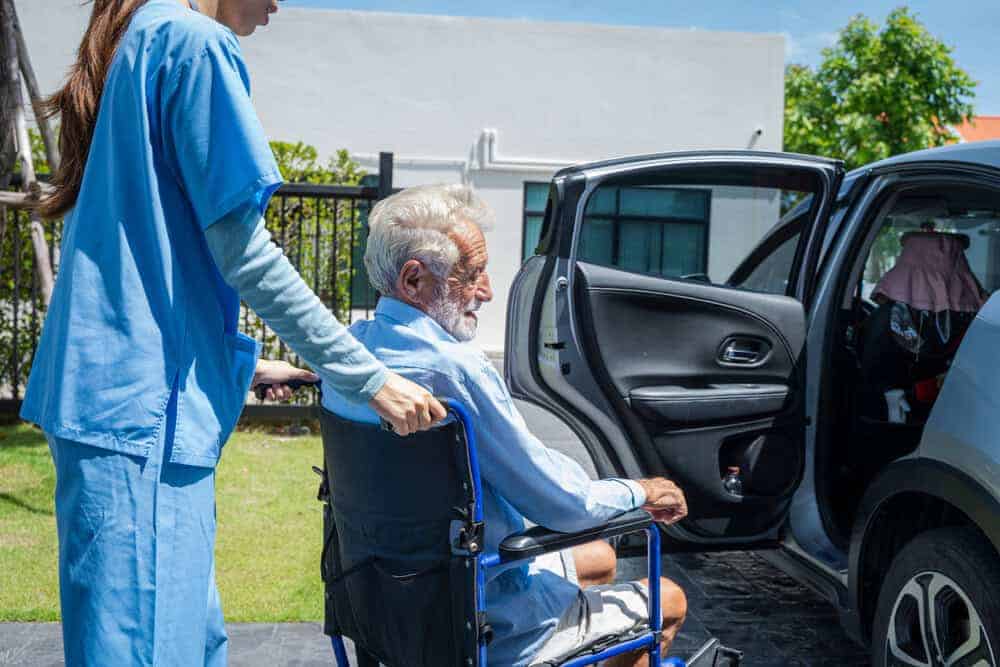 A caregiver providing assisted transportation for a senior to a medical appointment