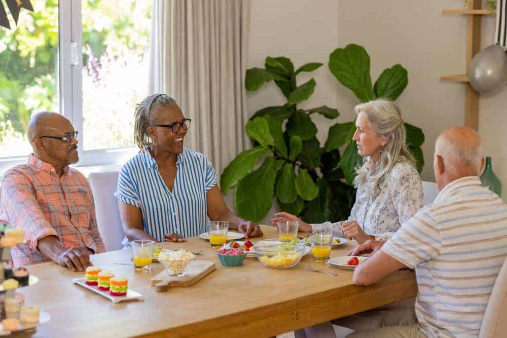 Residents enjoying a meal with their caregiver in a small residential care home in Reno.